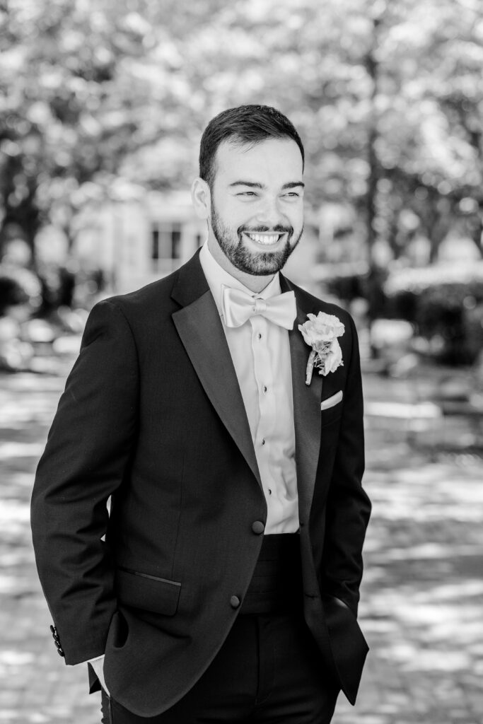 A groom smiling off camera for a portrait before his Sheraton Reston wedding