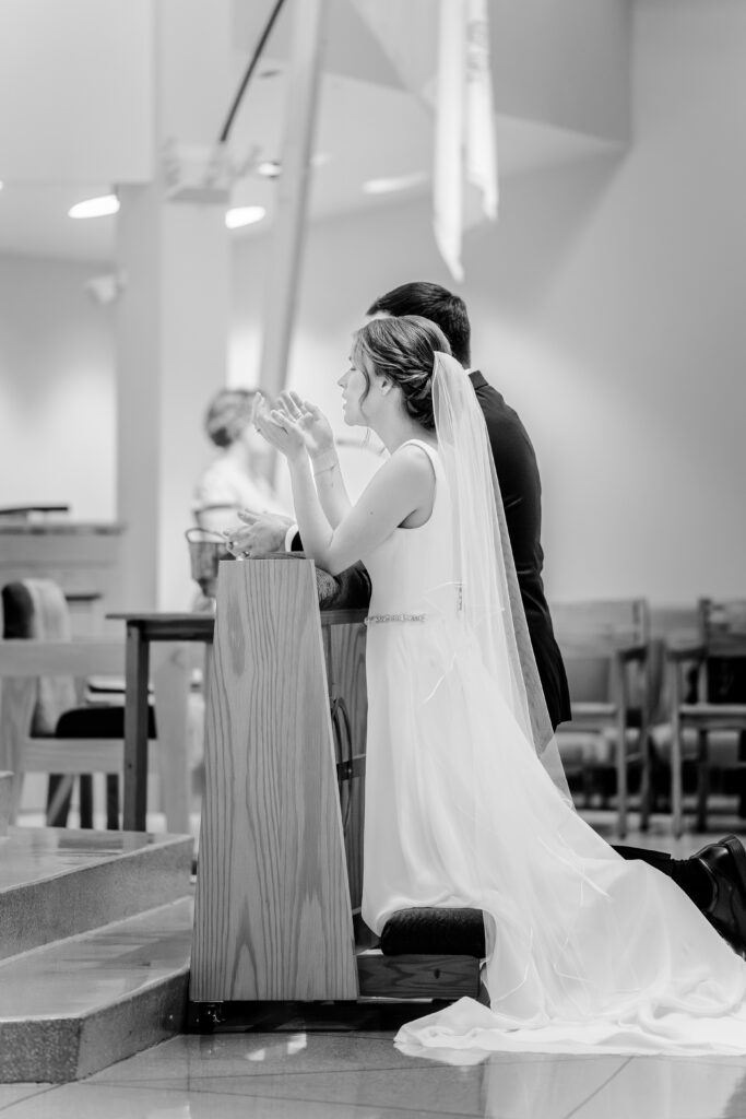 A bride raises her hands in worship during a wedding at St. Joseph Catholic Church in Herndon, Virginia