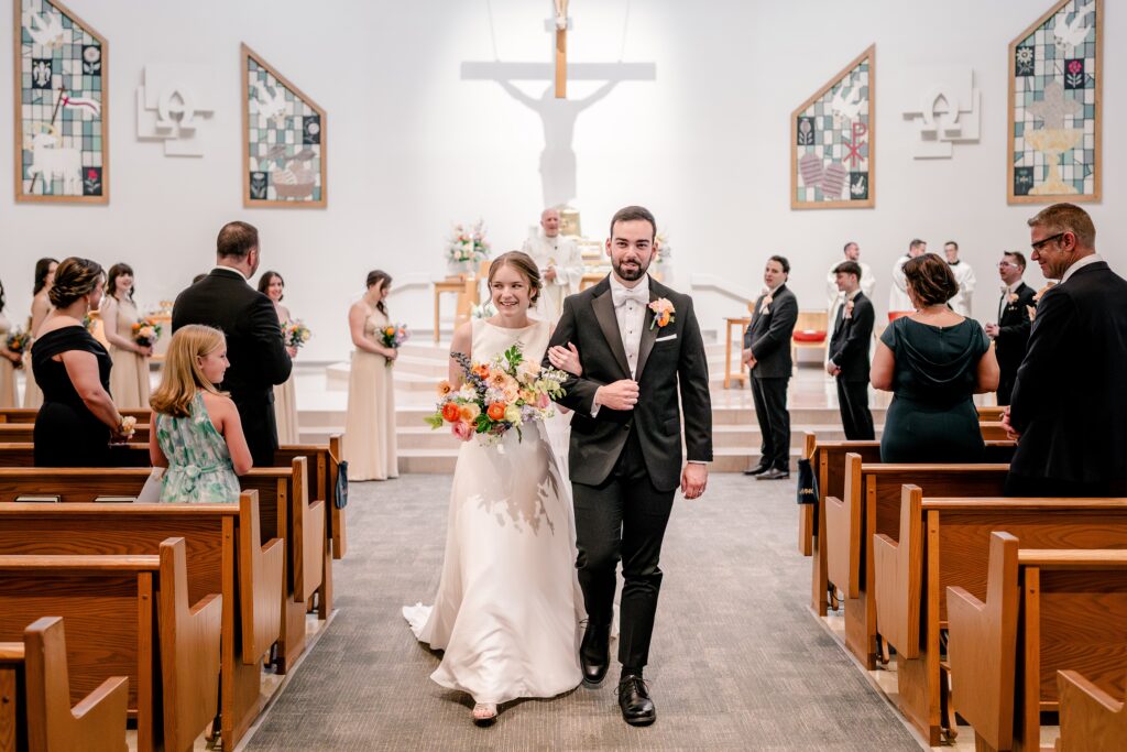 A bride and groom recess at the end of their wedding at St. Joseph Catholic Church in Herndon, Virginia