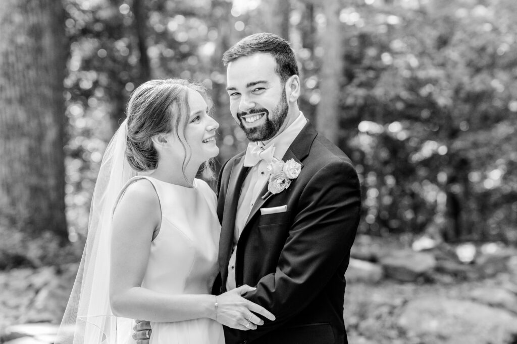 A bride smiles at her groom during their portraits before a Sheraton Reston wedding reception