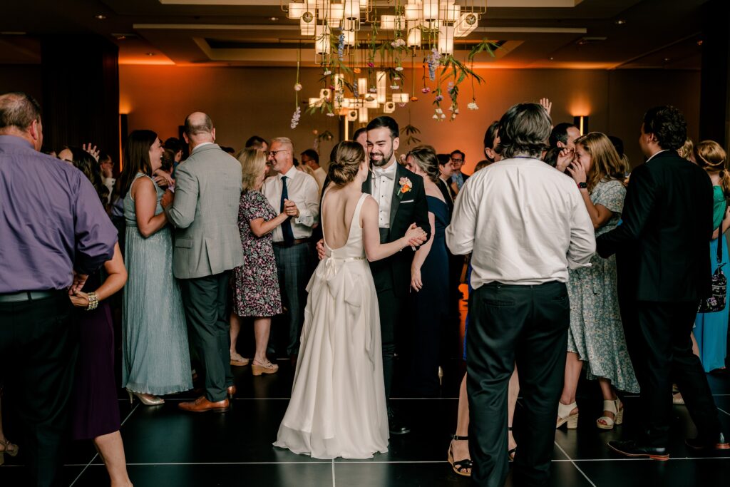 The bride and groom in the middle of the dance floor during a slow dance at their Sheraton Reston wedding reception