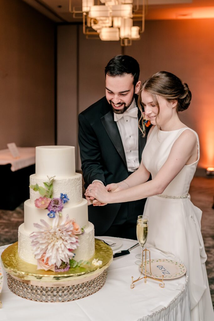 The bride and groom cutting the cake during their Sheraton Reston wedding reception