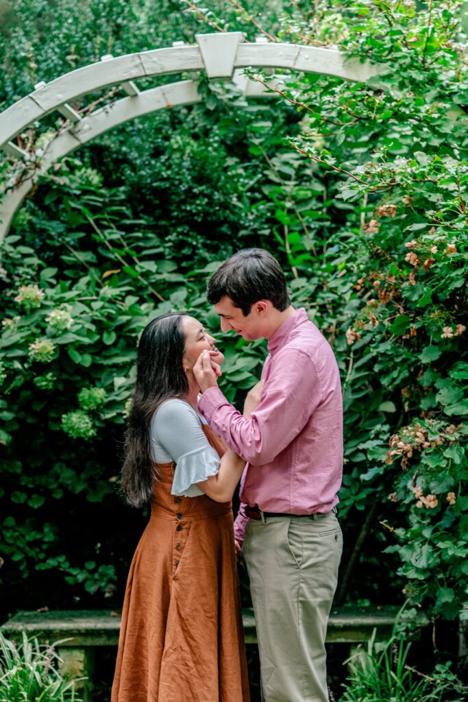 An engaged couple sharing a tender moment in a secret garden