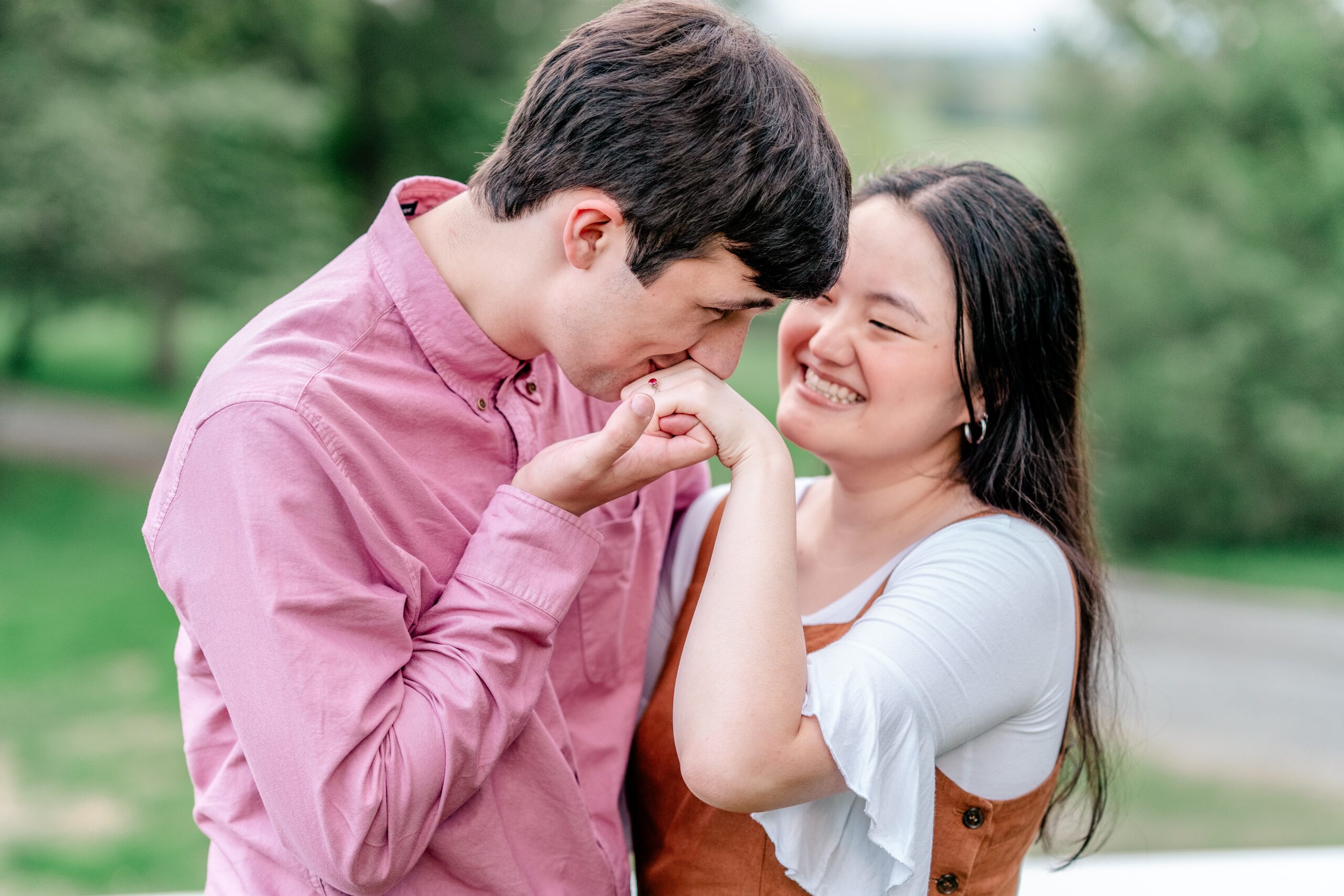 A man kisses his fiancee's hand during their engagement session at Oatlands Historic House in Northern Virginia