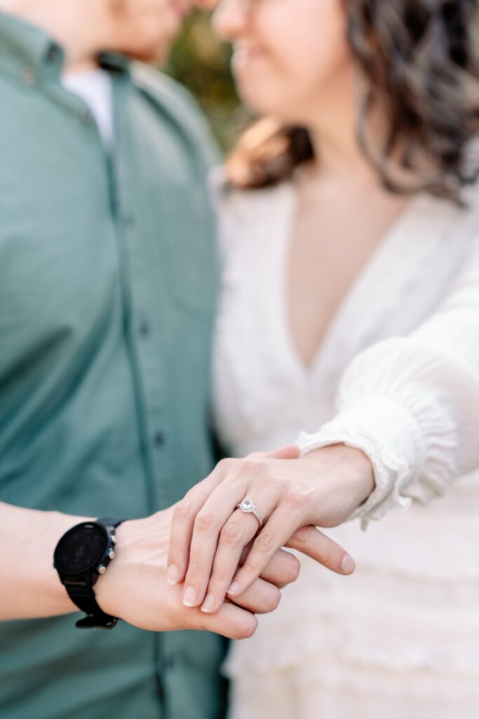 A couple showing off the ring during their Brookside Gardens engagement session in Silver Spring, MD