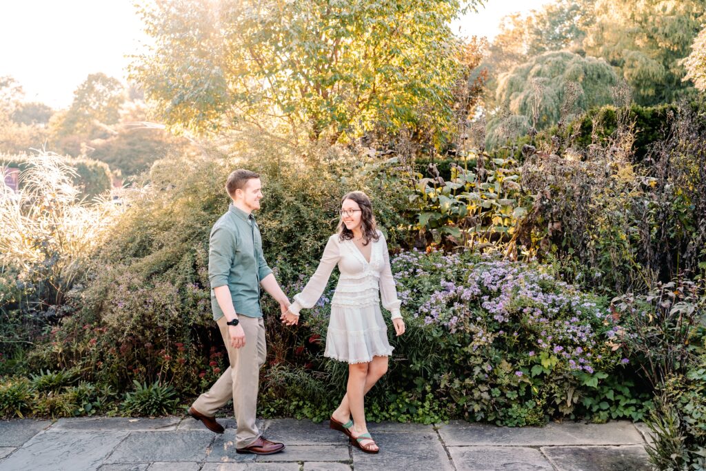 An engaged couple holding hands and walking together