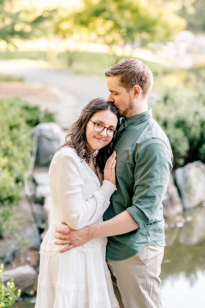 A man kissing the top of his fiancée’s head by Washington DC wedding photographer Beauty of the Soul Studio