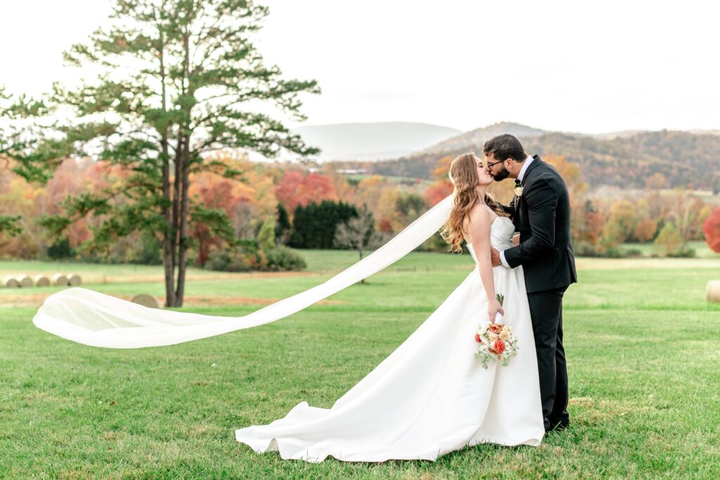 A bride and groom share a dramatic kiss during a fall wedding at The Barn at Edgewood