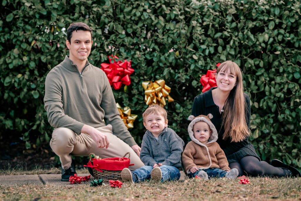 A family of four posing for a Christmas photo