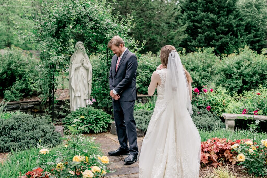 A bride and groom's first look in a garden before their Catholic wedding in Fredericksburg