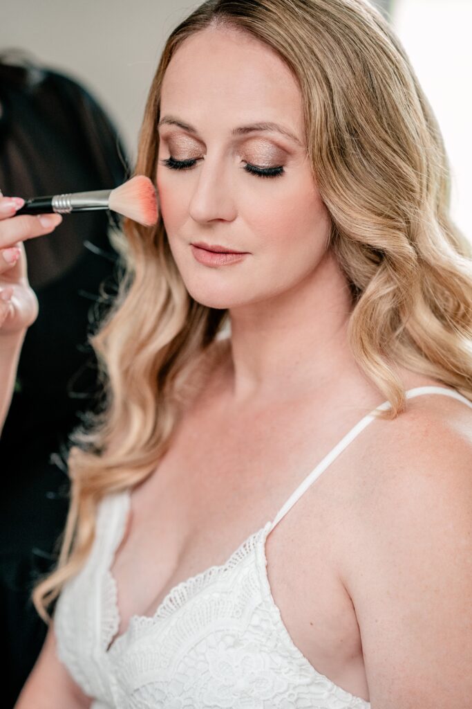 A bride receiving makeup services, by Northern Virginia wedding photographer Beauty of the Soul Studio