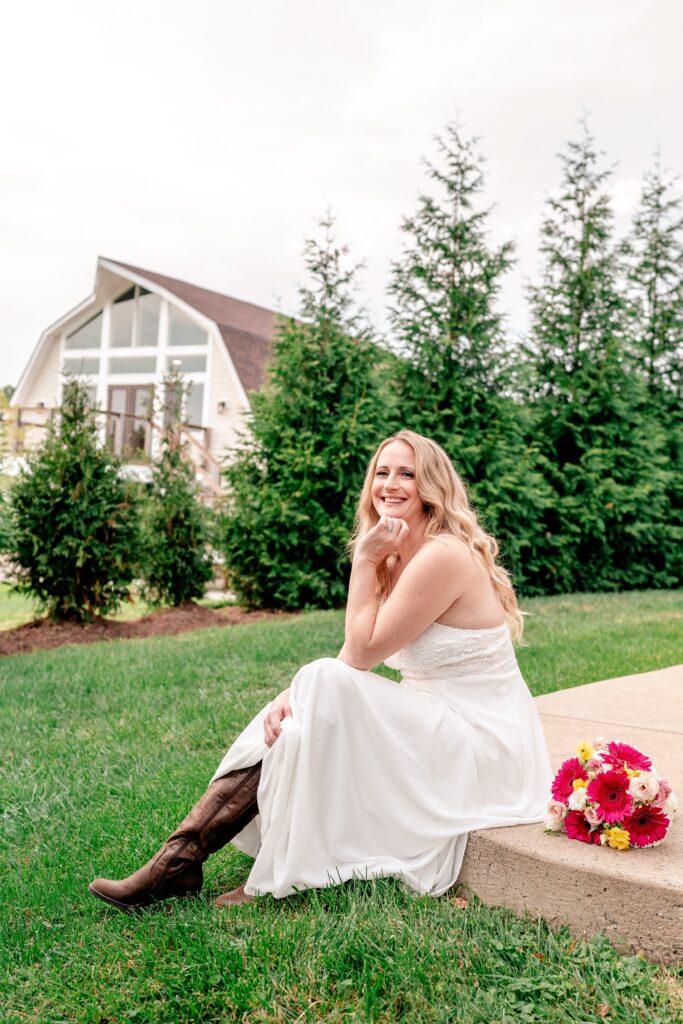 A bride in cowboy boots smiling in front of Halcyon Watson