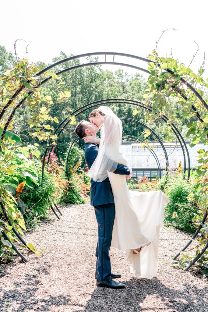 A bride and groom share a dramatic kiss during a wedding at The Atrium at Meadowlark Botanical Gardens