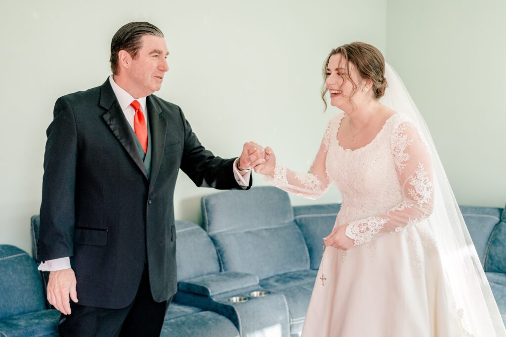 A father and daughter laugh together during their first look on her wedding day