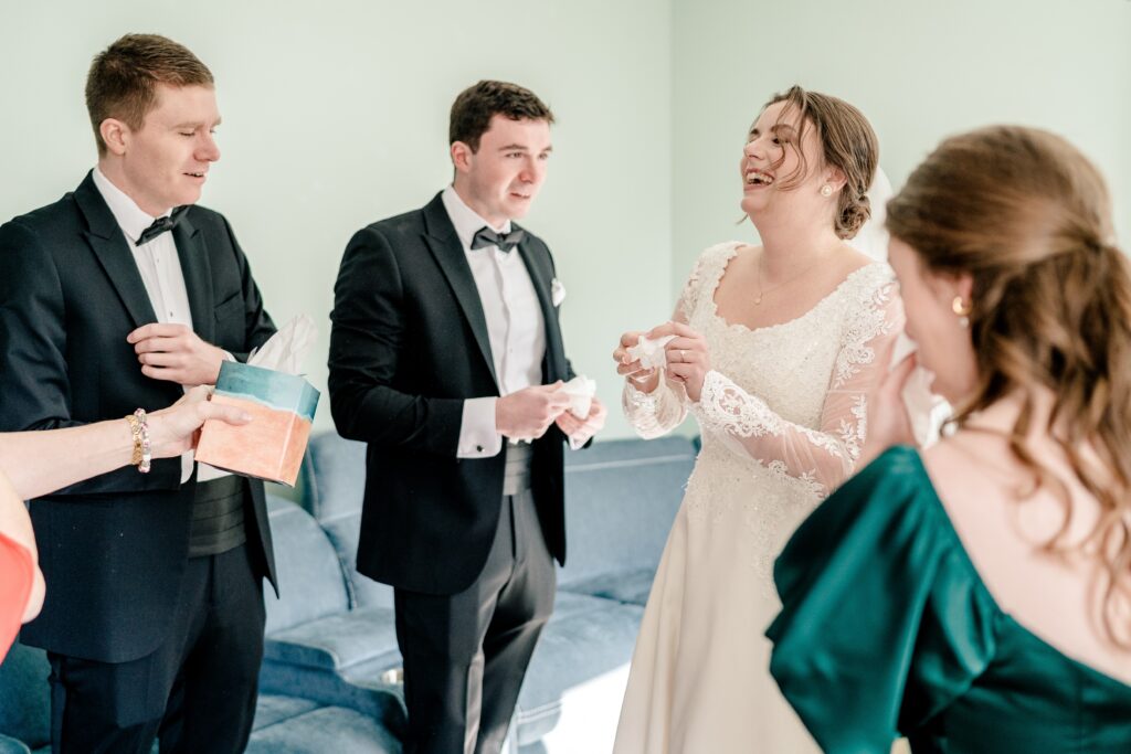 A group of siblings pass around a box of tissues on a wedding day in Northern Virginia