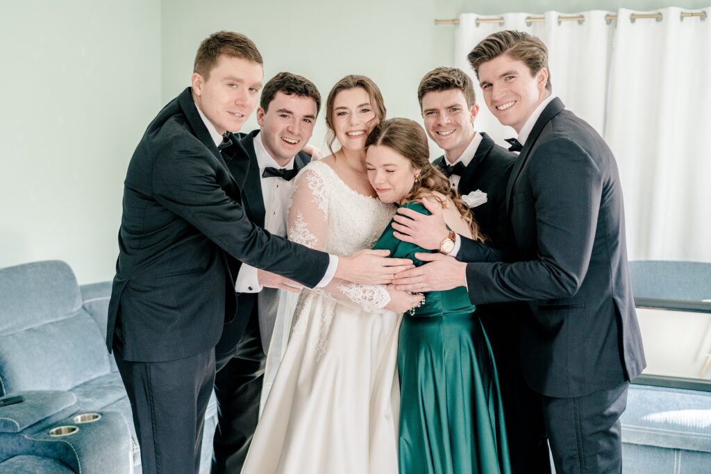 A family shares a group hug during a Catholic wedding day