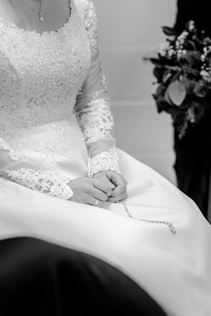 A close up of a bride's hands as she prays a rosary before her wedding