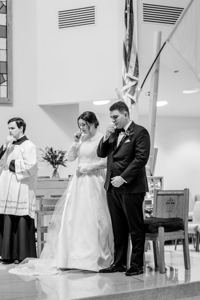 A bride and groom during the Gospel reading on their wedding day