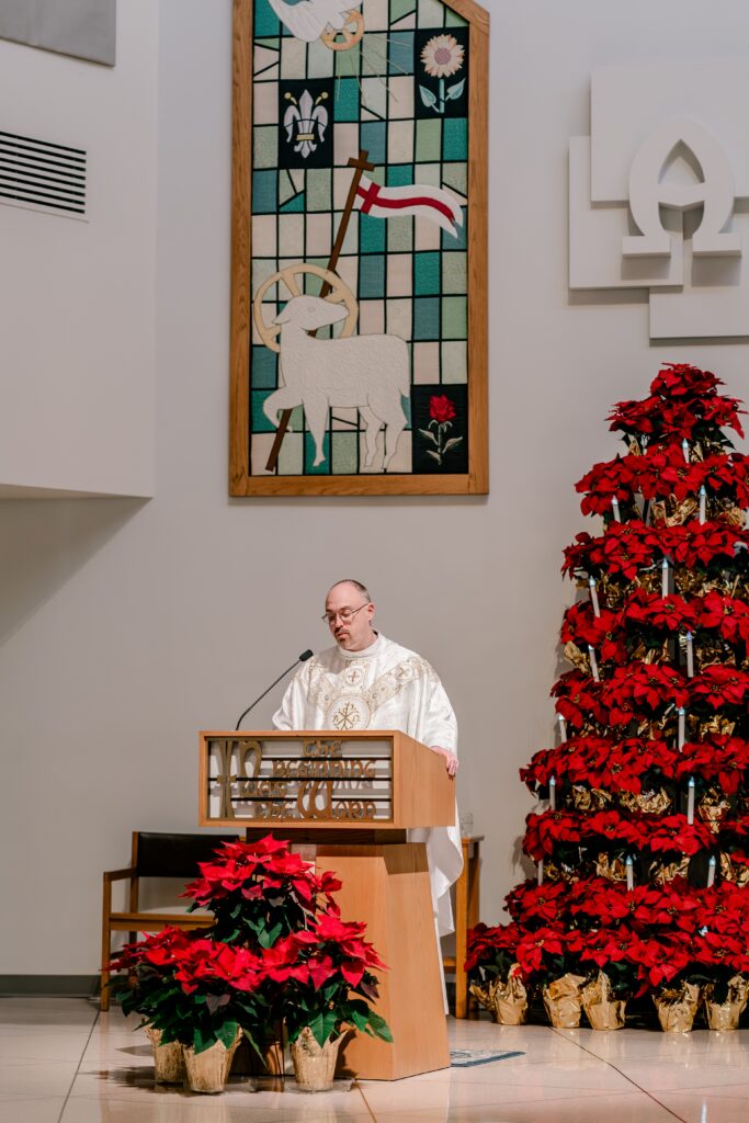 A priest reading from the pulpit during a Christmas themed wedding at St. Joseph Catholic Church in Herndon Virginia