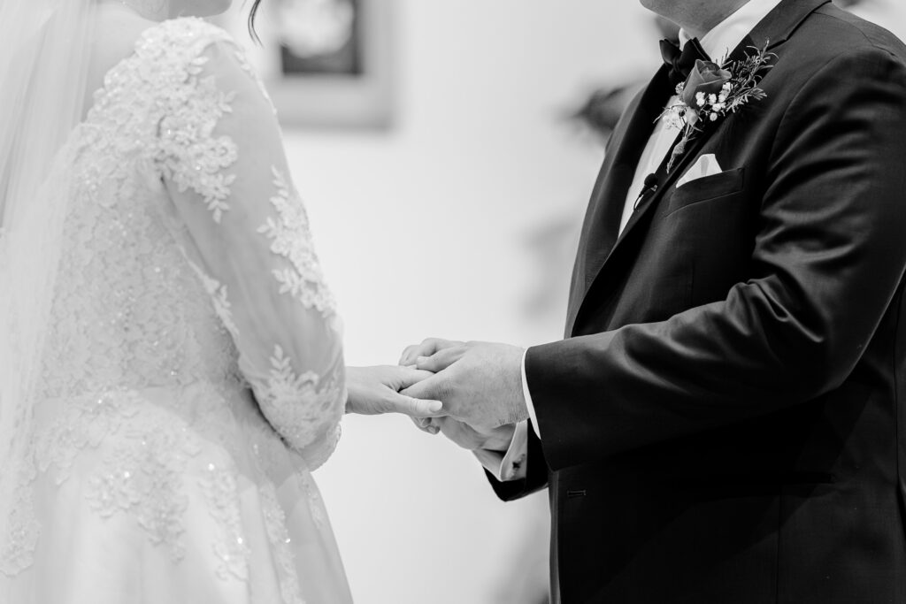 A close up of the bride and groom's hands as they exchange rings