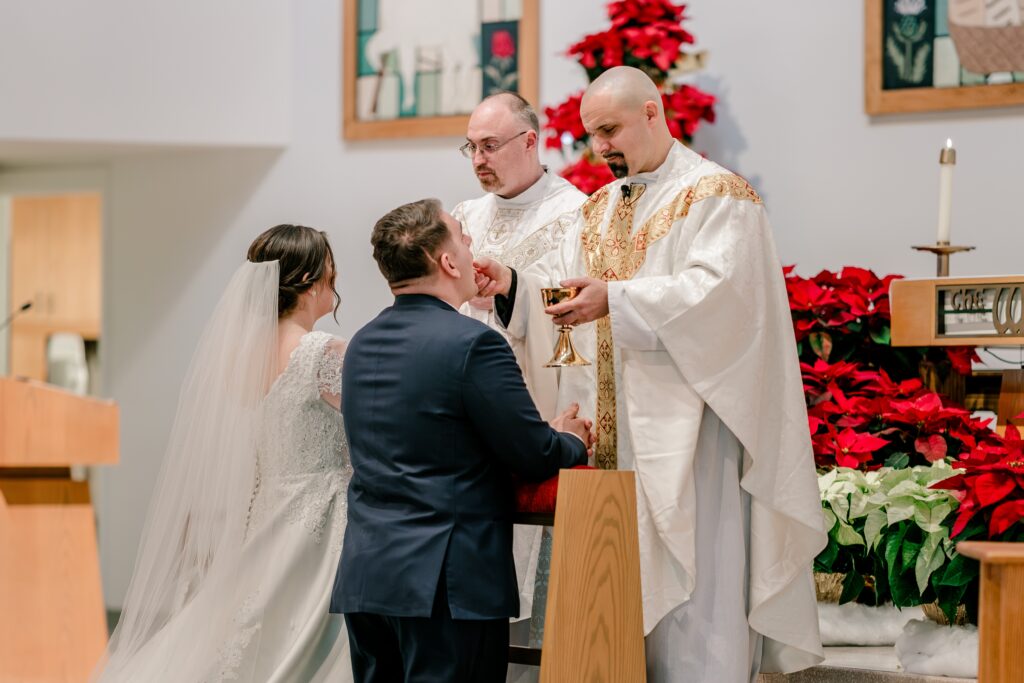 A groom receiving Communion during a Catholic wedding in Northern Virginia