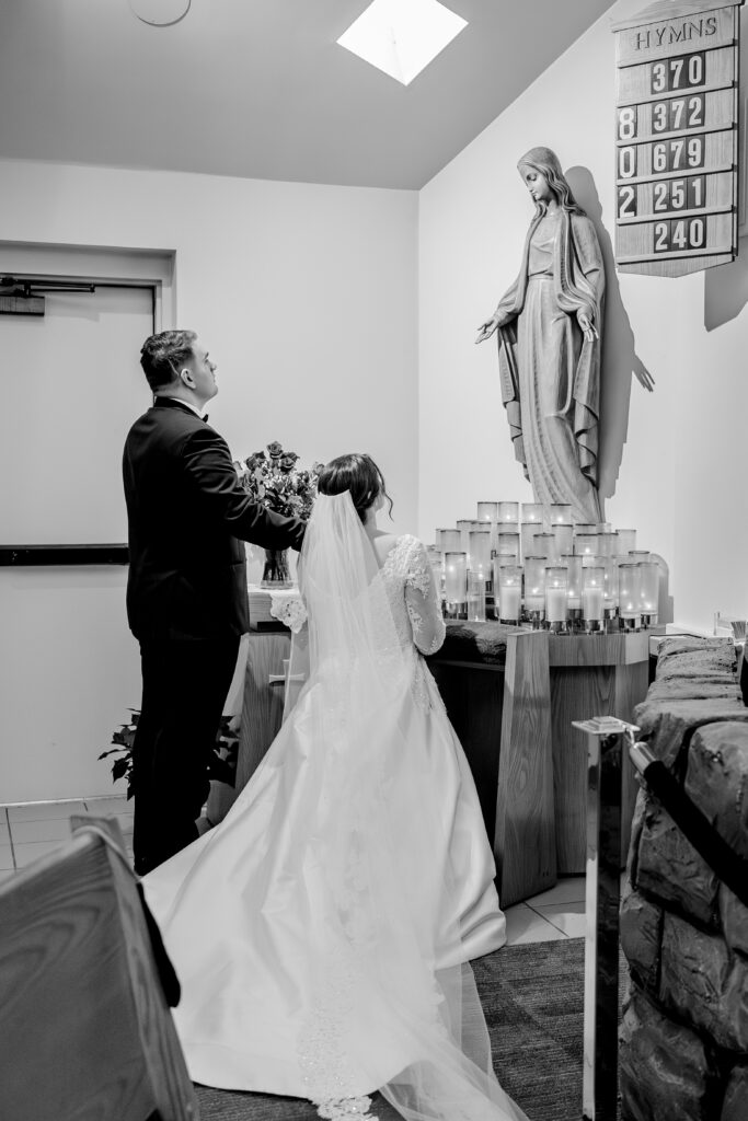 A bride and groom presenting flowers to Mary for their Catholic wedding in Northern Virginia