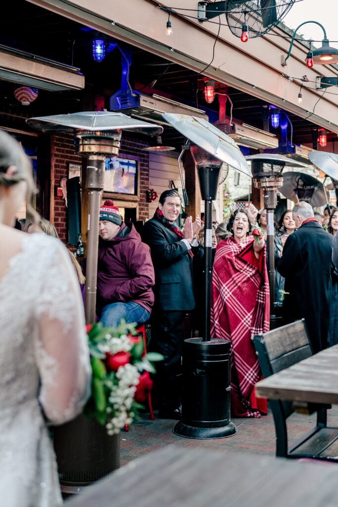 Friends and family cheer as the bride and groom enter the room