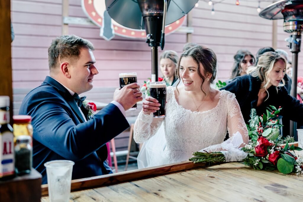 A bride and groom cheers with Guinness pints during a Christmas themed wedding in Herndon Virginia