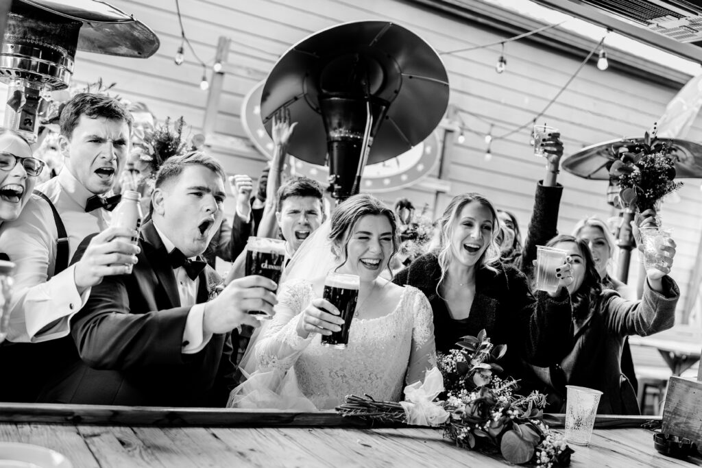 A wedding party celebrates at the bar during a Christmas themed wedding in Herndon Virginia