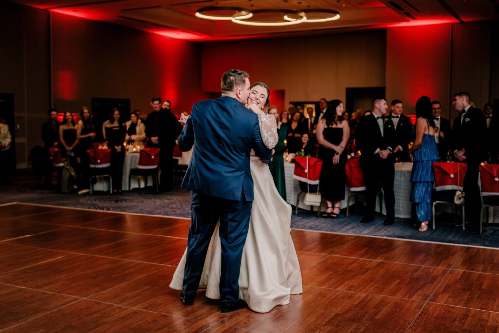 A groom kisses his bride on the cheek during a Christmas themed wedding at the Hyatt Regency Dulles in Herndon Virginia