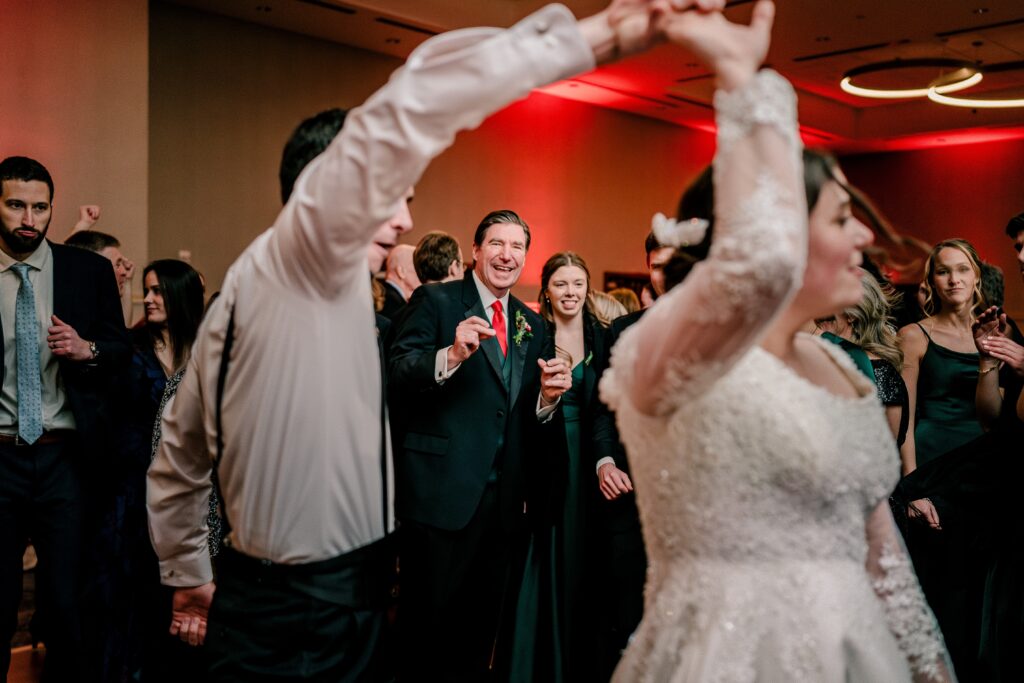 Family watch as the bride dances with her brother during a Christmas themed wedding at the Hyatt Regency Dulles in Herndon Virginia