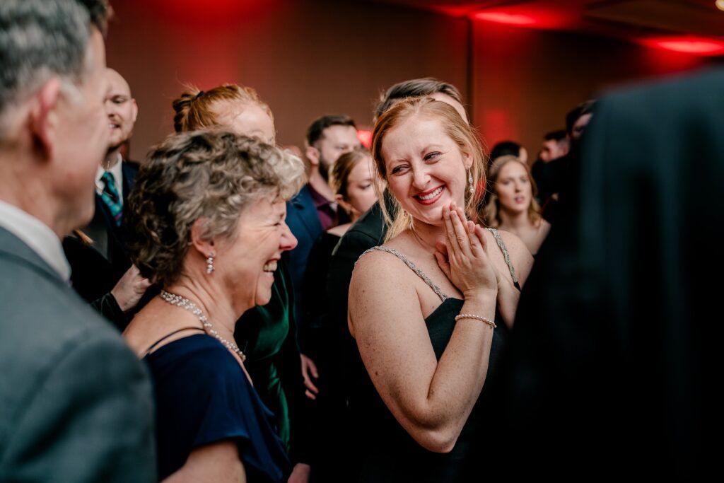 Wedding guests smile at each other as they dance during a Christmas themed wedding at the Hyatt Regency Dulles in Herndon Virginia