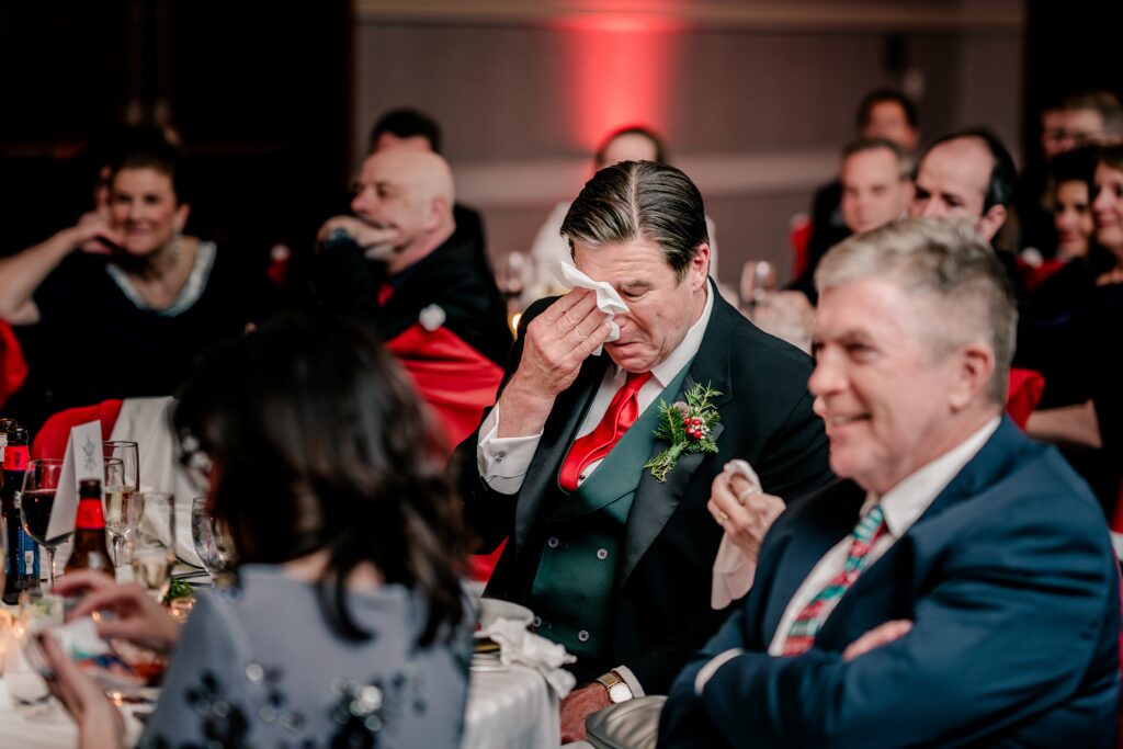 The Father of the Bride wipes tears during a wedding reception at the Hyatt Regency Dulles in Herndon VA