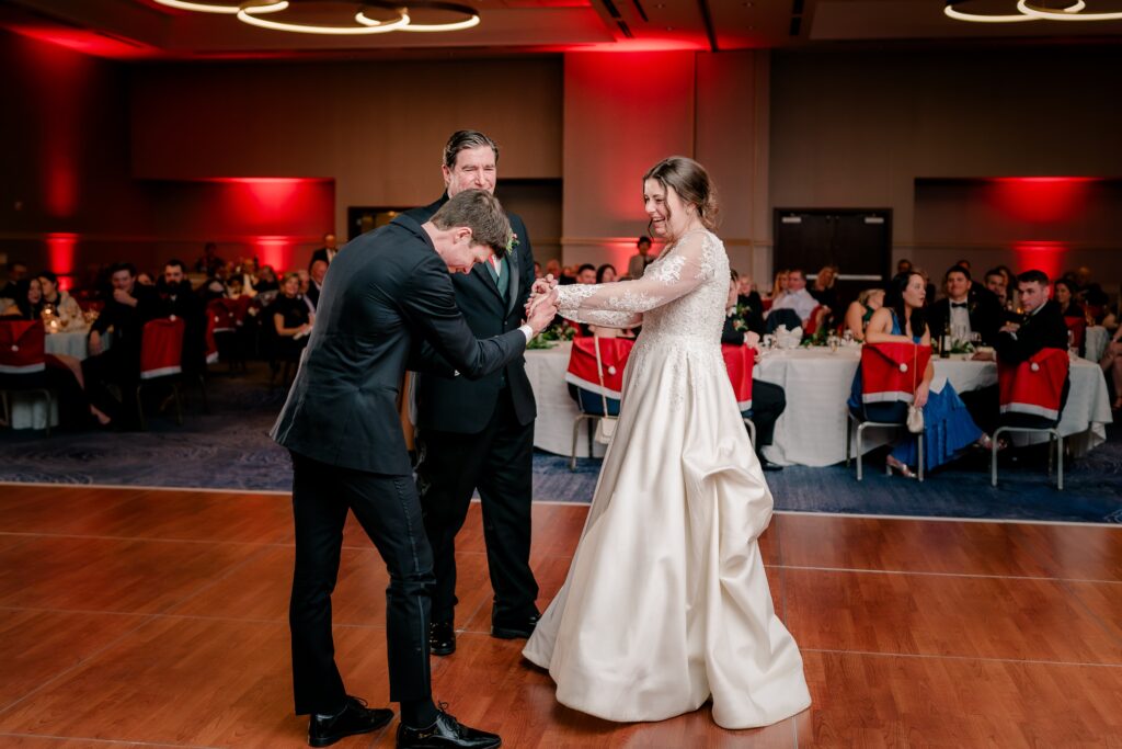 The bride's brother cuts in for a dance during a Christmas themed wedding at the Hyatt Regency Dulles in Herndon Virginia