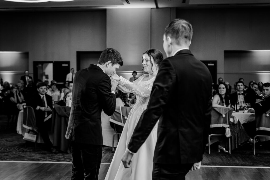 A sweet moment between the bride and her brothers during a Christmas themed wedding at the Hyatt Regency Dulles in Herndon Virginia