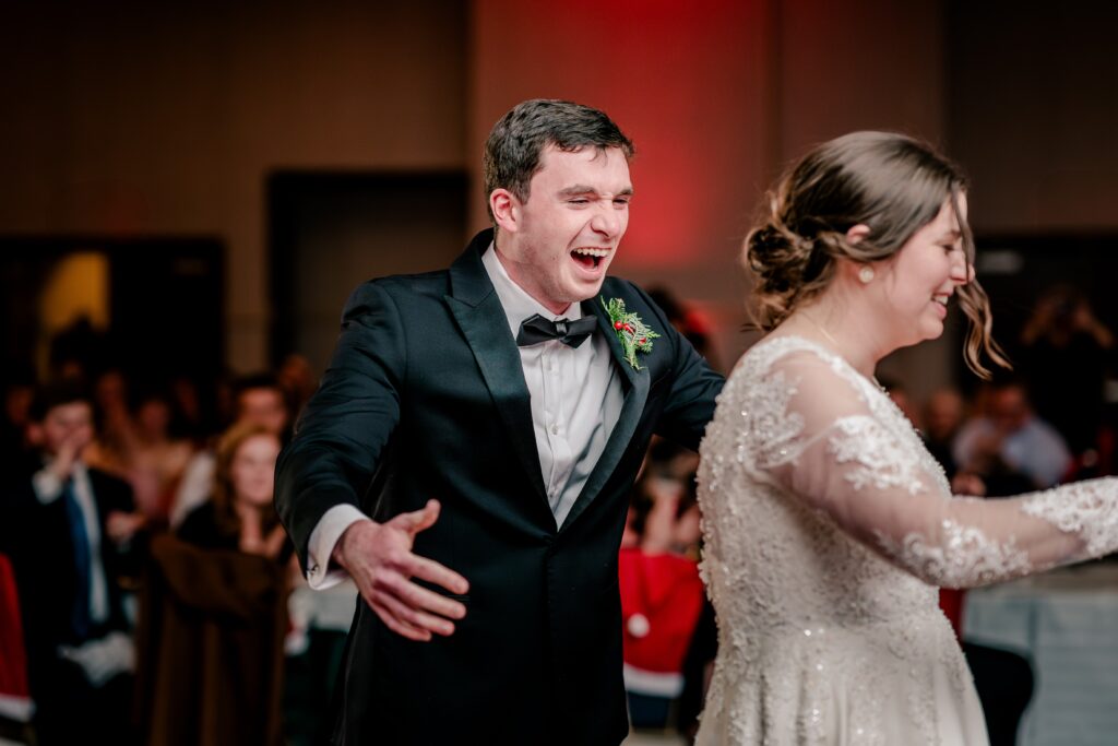 The brother of the bride laughing as his dance with her gets cut short