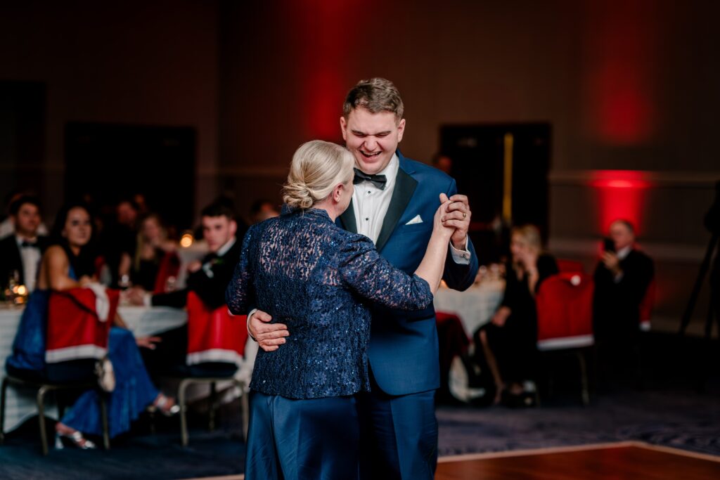 A groom laughing as he dances with his mother during a Christmas themed wedding at the Hyatt Regency Dulles in Herndon Virginia