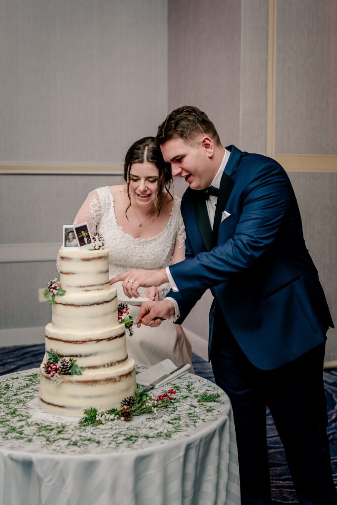 A bride and groom cut the cake together