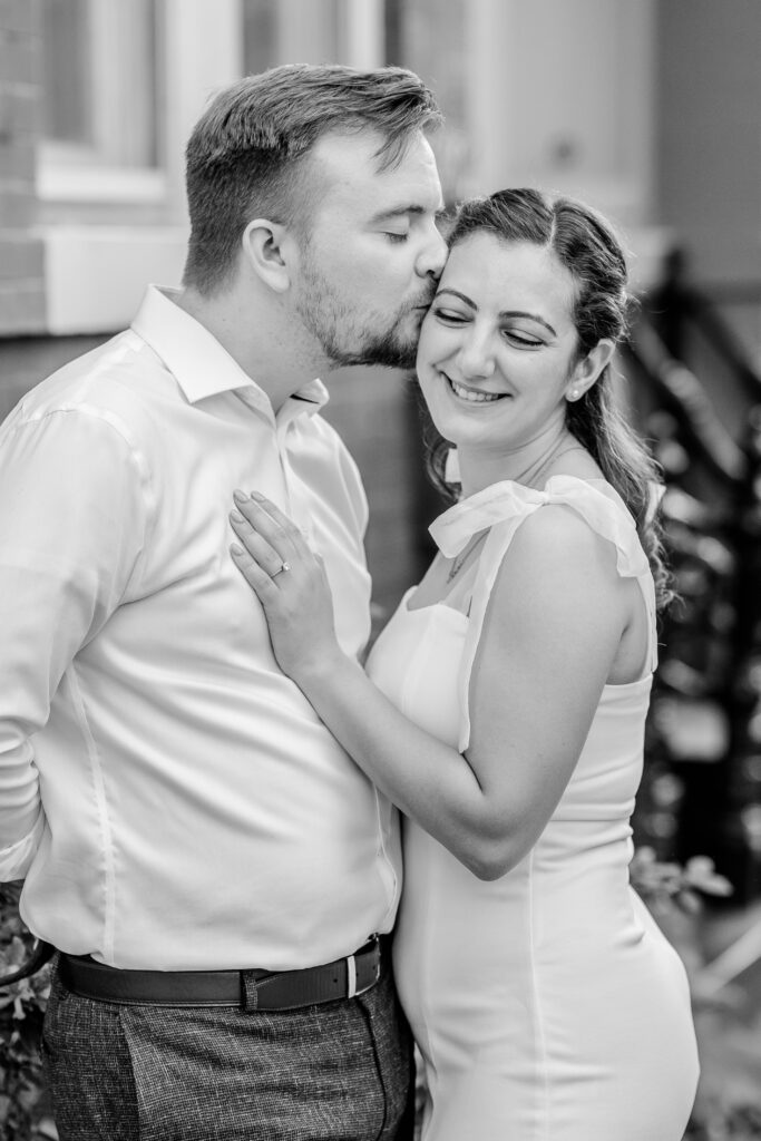 A man kisses his bride to be on the cheek in a photo by Georgetown wedding photographer