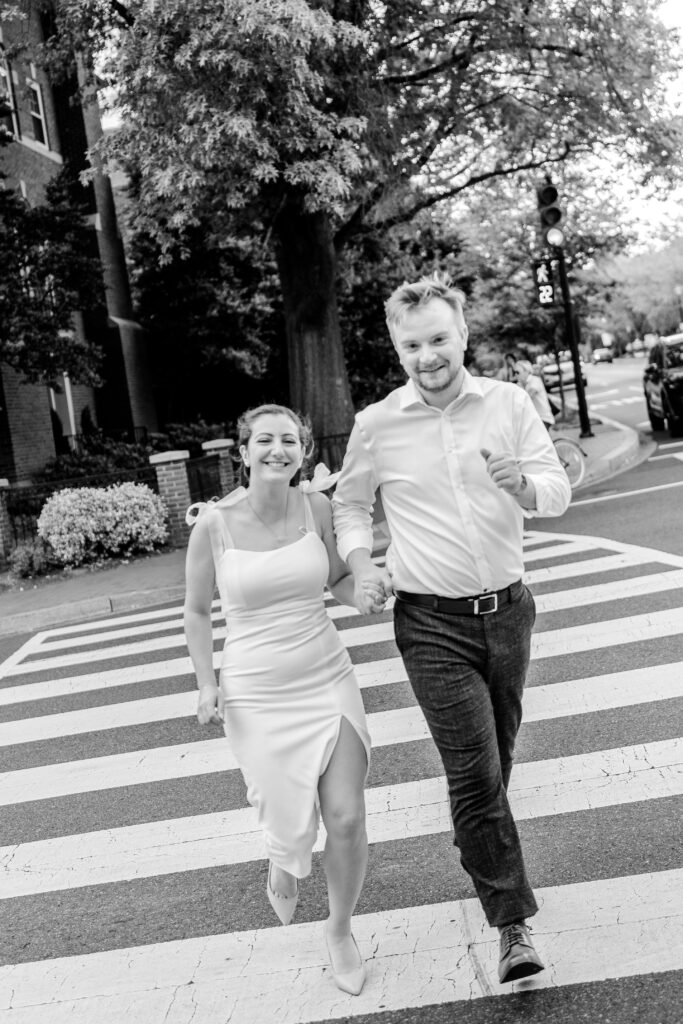 A couple runs across the street together