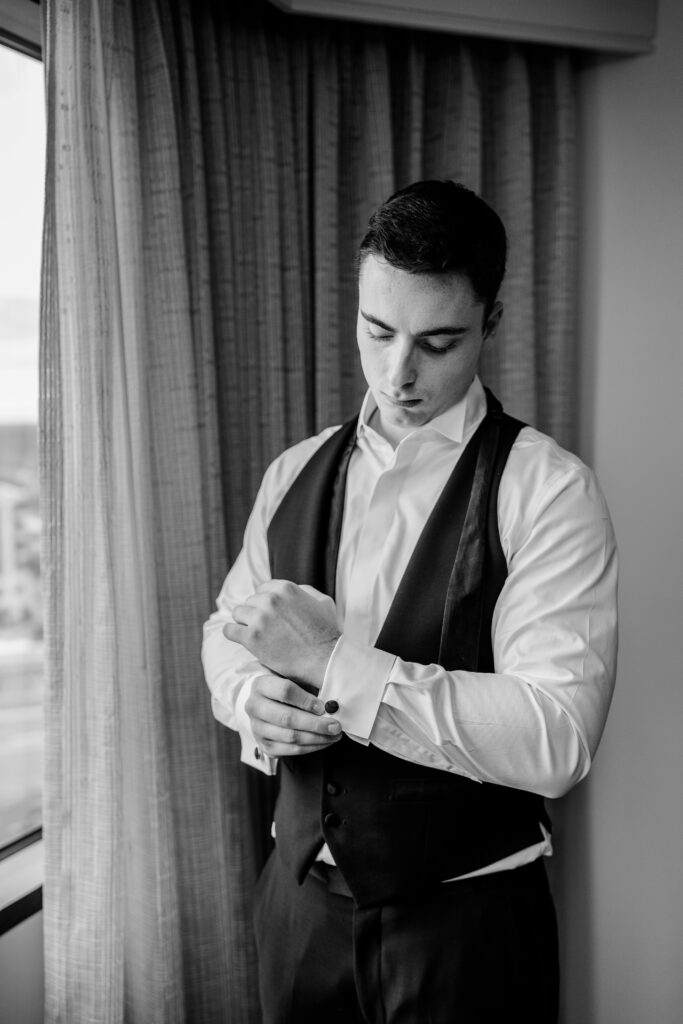 A groom getting dressed for his St Dominic DC wedding
