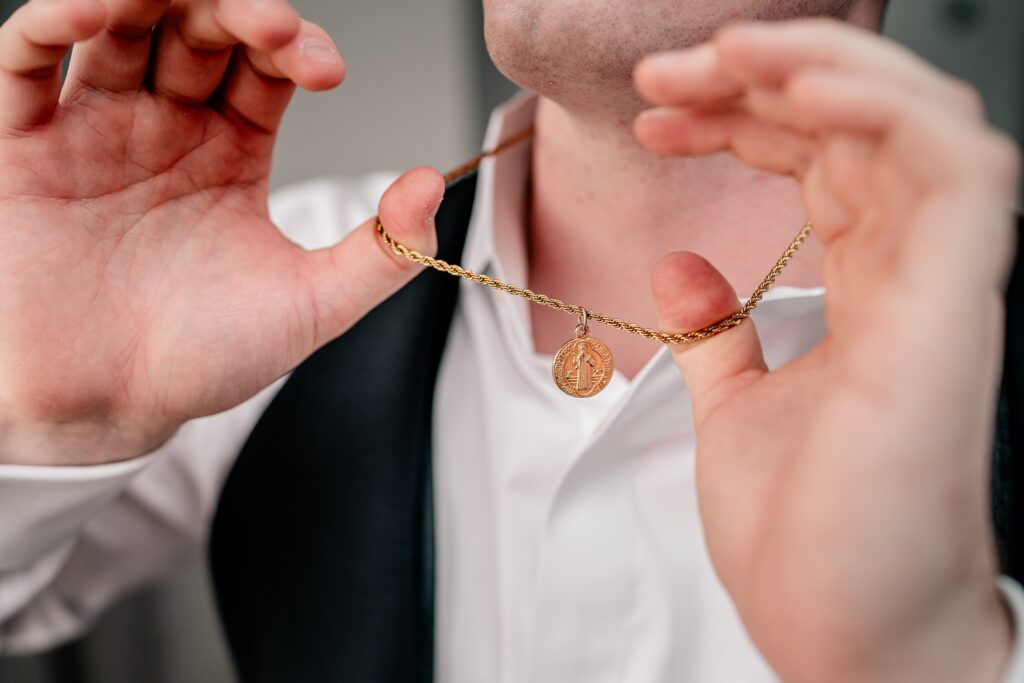 A groom holding out his saint medal ahead of his St Dominic DC wedding