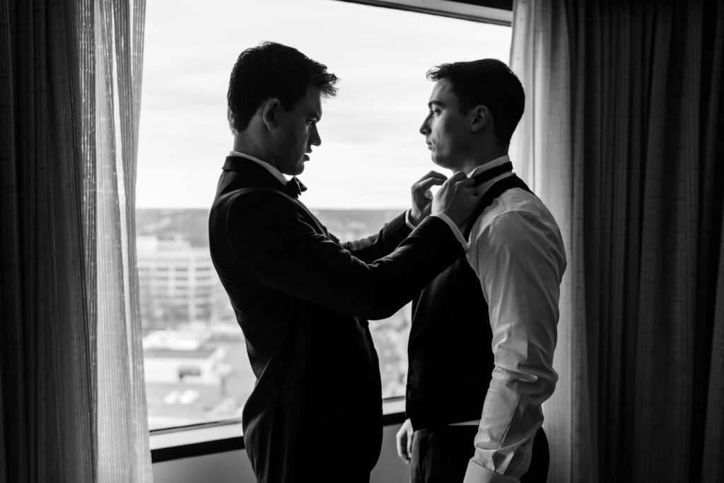 A groomsman helping the groom get dressed for his DC Christmas wedding