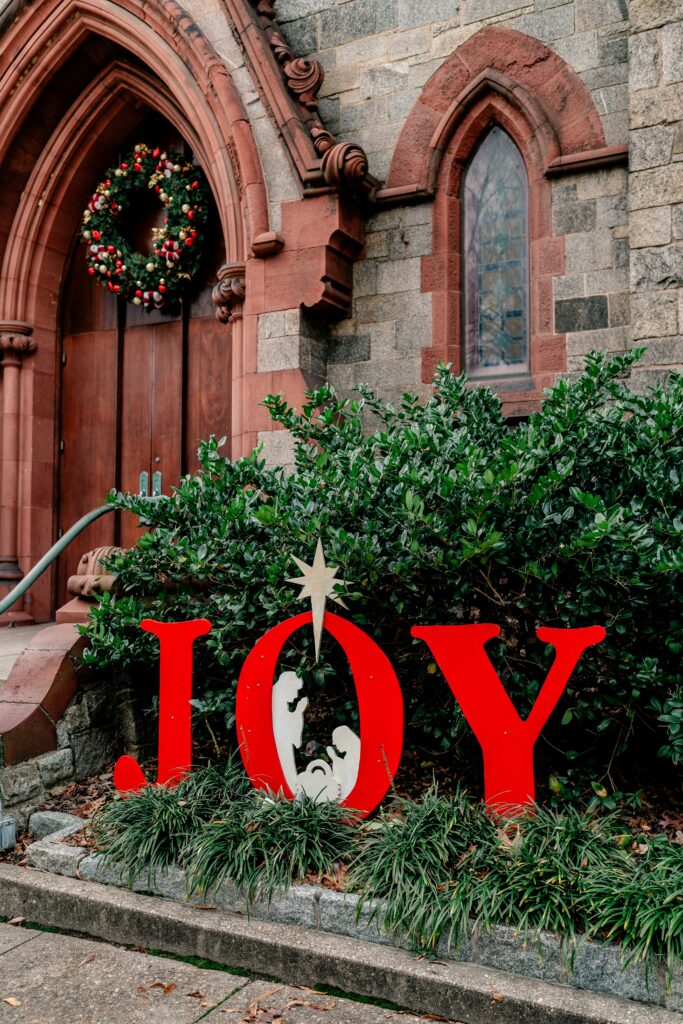 A sign that says JOY outside the church before a wedding by Northern Virginia wedding photographer Beauty of the Soul Studio