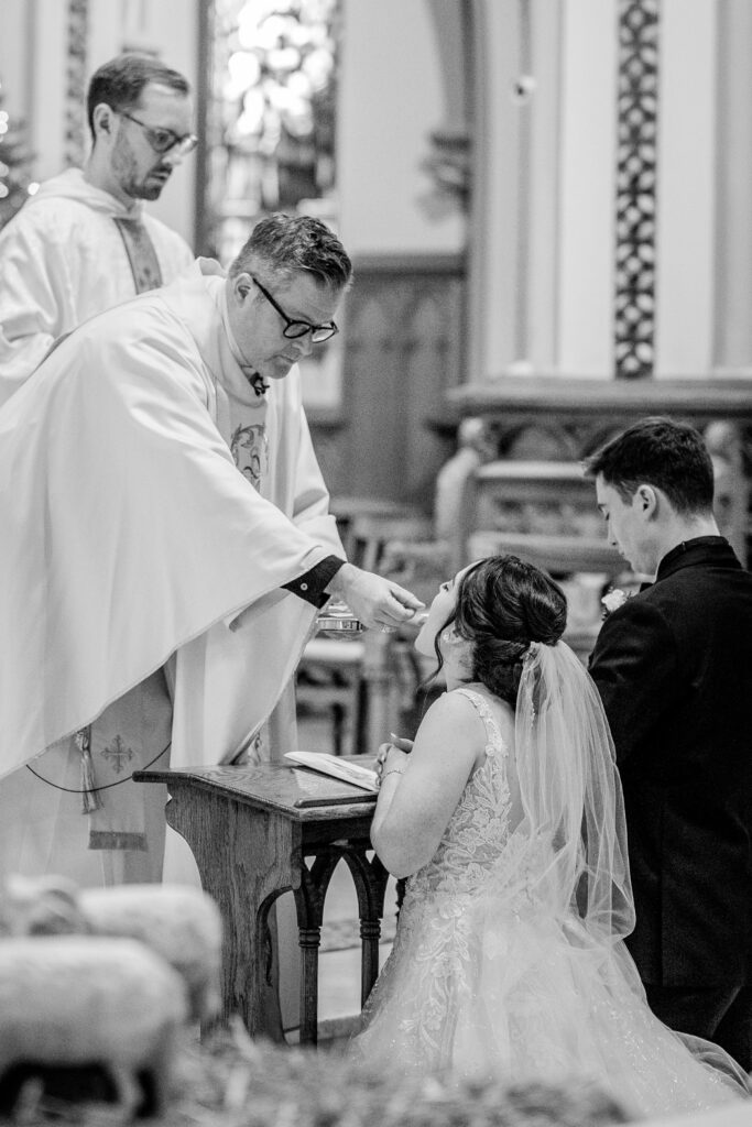 A bride receiving communion during her St Dominic DC wedding