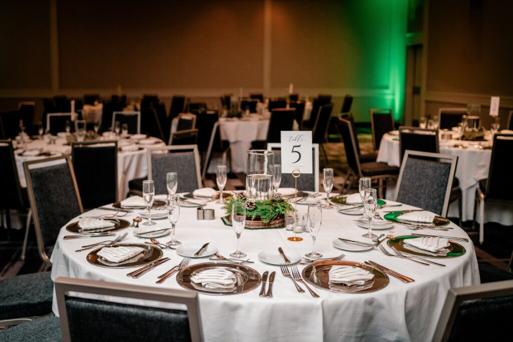 A wedding reception featuring an evergreen wreath centerpiece