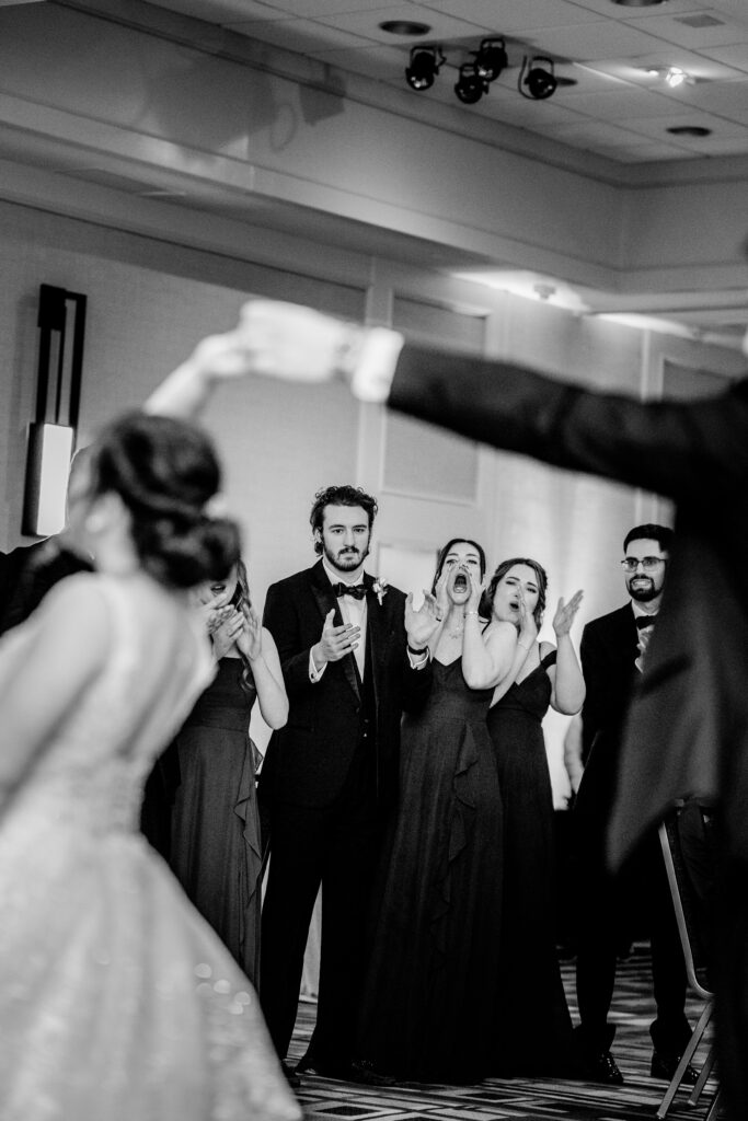 A wedding party cheering on the bride and groom during their first dance snapped by Northern Virginia wedding photographer Beauty of the Soul Studio