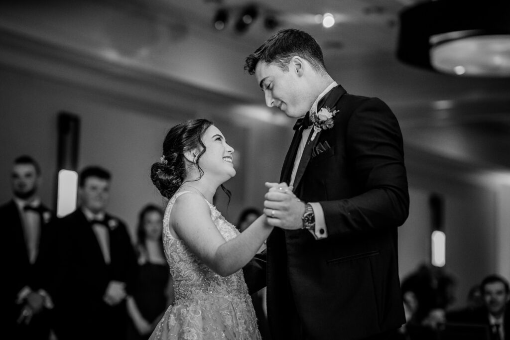 A bride and groom smile at each other during their first dance