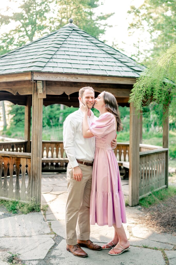 A woman kisses a man on the cheek for their Green Spring Gardens photos