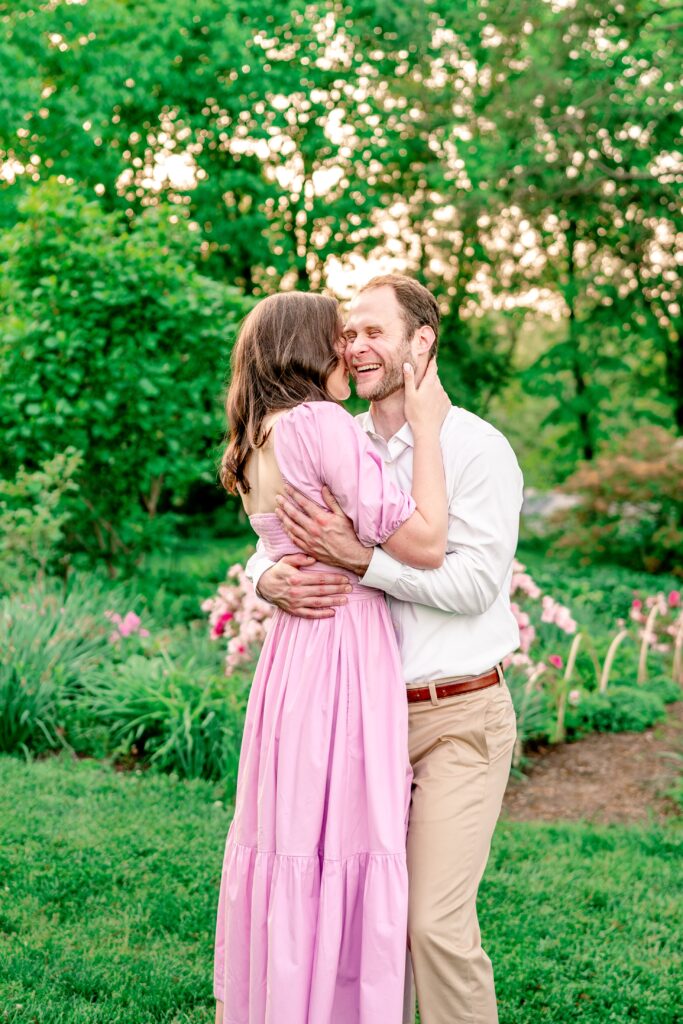 A sweet candid of a couple sharing an embrace while laughing during their Green Spring Gardens photos